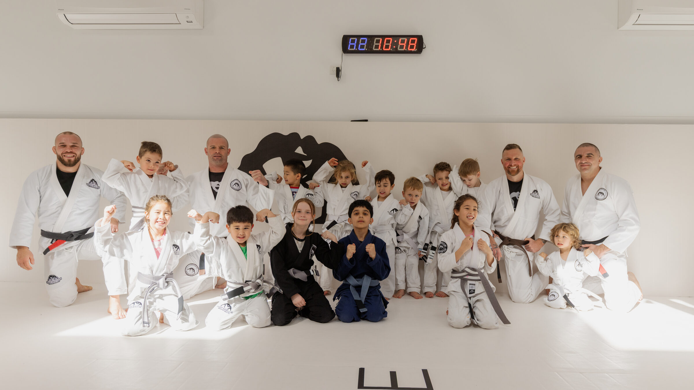 The kids class and their coaches together on the mats at Inner Westside BJJ